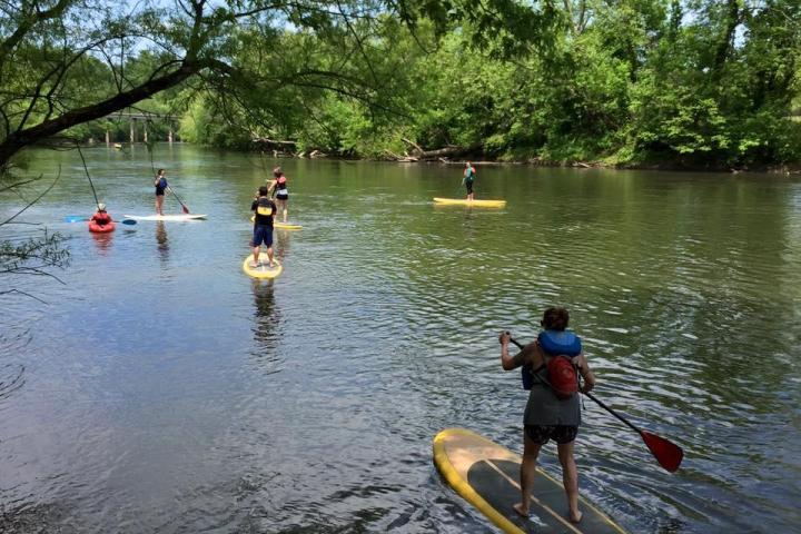 a group of people riding on the back of a boat in the water