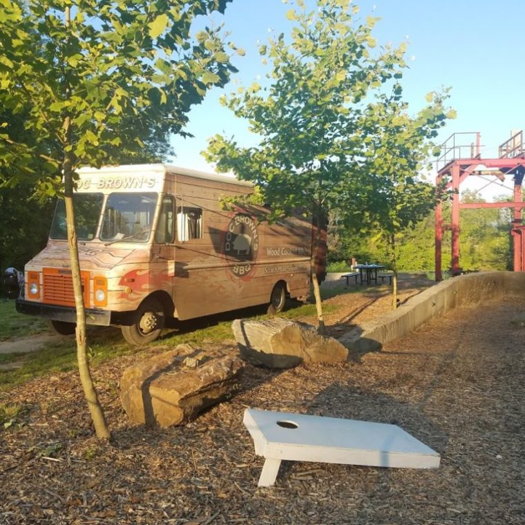 a yellow school bus parked in front of a tree