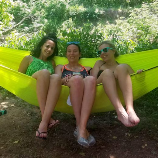 a woman sitting on a beach holding a surfboard