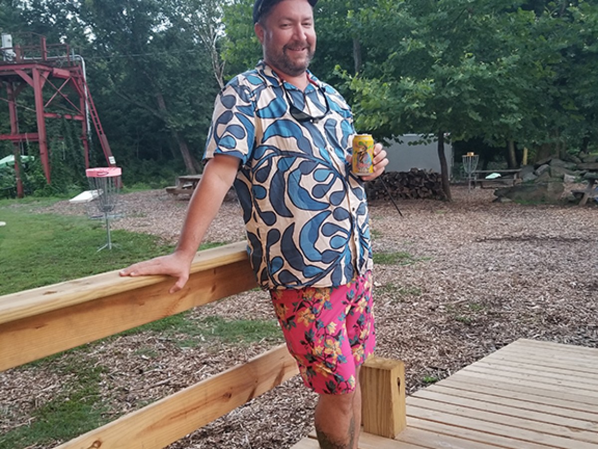 a man standing on top of a wooden bench