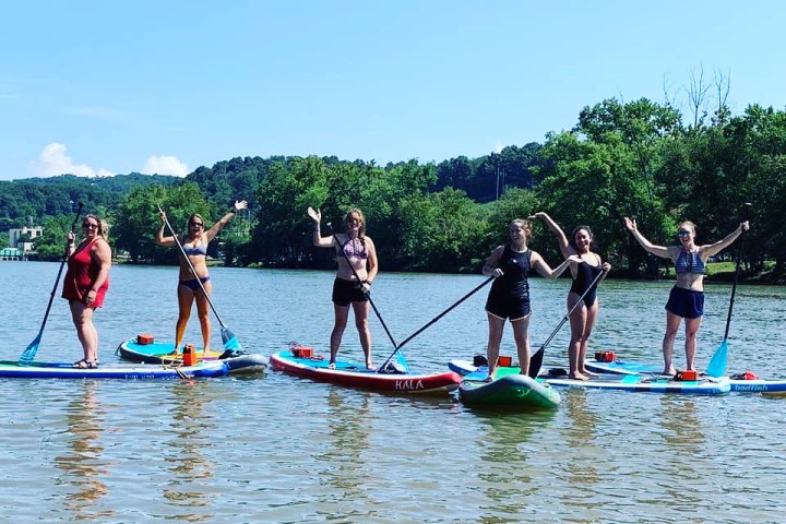 a group of people rowing a boat in the water